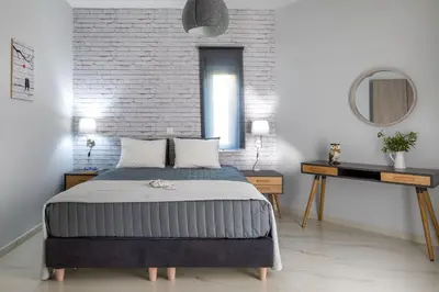 a bedroom with a bed and a brick wall at E&G Relax Homes-E in Kissamos