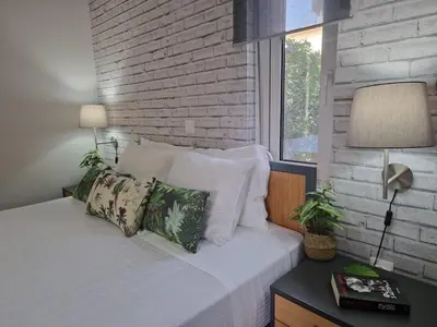 a bedroom with a white bed with a brick wall at E&G Relax Homes-E in Kissamos