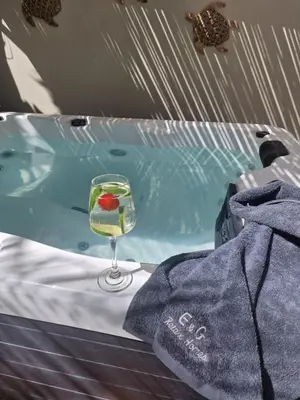 a glass of wine sitting next to a bath tub at E&G Relax Homes-E in Kissamos