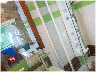 a bathroom with a shower and a sink and a mirror at Meliti Sunset View & Private Pool Villa 20 min from Elafonissi in Livadia