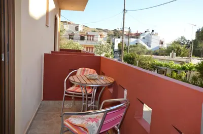 a small table and two chairs on a balcony at Kochyli Studios in Palaiochóra
