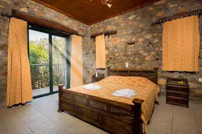 a bedroom with a bed and a stone wall at Villa Livadia with Pool, close to Elafonissi famous Beach in Livadia