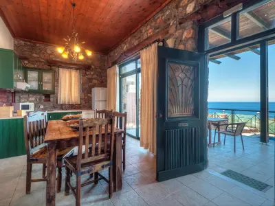 a dining room with a table and a view of the ocean at Villa Livadia with Pool, close to Elafonissi famous Beach in Livadia