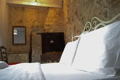 a bedroom with a white bed with a stone wall at Yro Studios in Chania Town