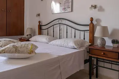two beds with white sheets and pillows in a bedroom at Poseidon Studios Chania Center in Chania Town