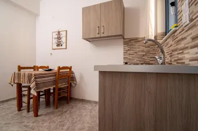 a kitchen and dining room with a table and chairs at Virginia Studios in Palaiochóra
