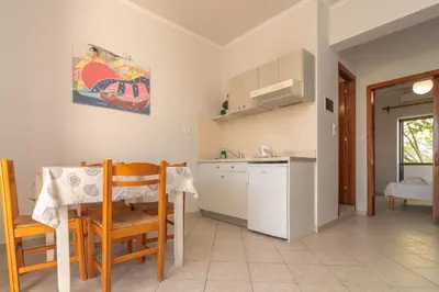 a kitchen with a table and chairs and a sink at Virginia Studios in Palaiochóra