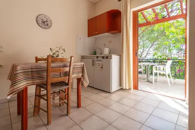 a kitchen with a table and a refrigerator at Virginia Studios in Palaiochóra