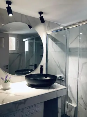a bathroom with a black sink and a mirror at Rafaellas Apartment in Chania Town