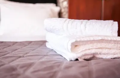 a pile of towels sitting on top of a bed at Rafaellas Apartment in Chania Town