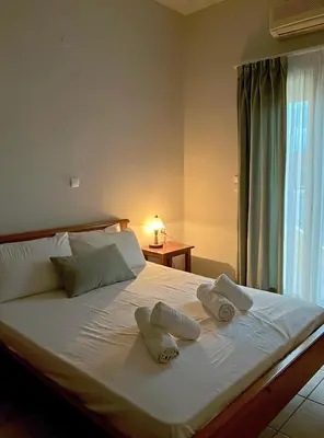 a bedroom with a bed with two towels on it at Panos Village in Maláxa