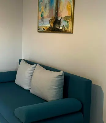 a blue couch with a pillow sitting under a painting at Panos Village in Maláxa