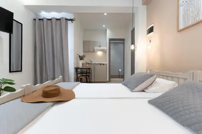 a bedroom with two beds with a hat on top at Romeos Studios in Agia Marina Nea Kydonias