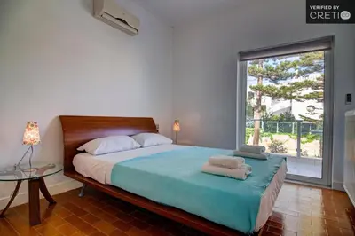 a bedroom with a bed and a large window at Villa Asteri in Kalamaki Chanion