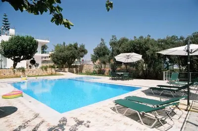 a swimming pool with two lawn chairs and umbrellas at Villa Asteri in Kalamaki Chanion