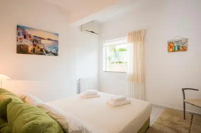 a white room with a bed and a window at Villa Asteri in Kalamaki Chanion