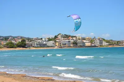 a kite flying over the ocean with a beach at Alexandra's Relaxing Suite in Kalamaki Chanion