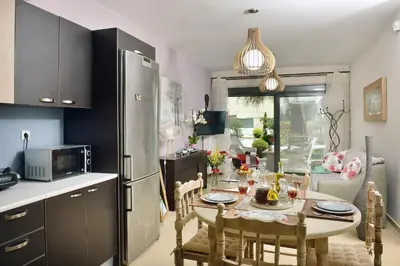 a kitchen with a table with chairs and a refrigerator at Alexandra's Relaxing Suite in Kalamaki Chanion