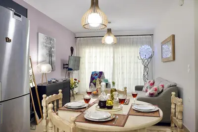 a kitchen and dining room with a table and a refrigerator at Alexandra's Relaxing Suite in Kalamaki Chanion