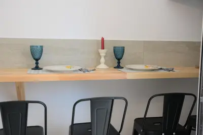 a table with three plates and three glasses and a candle at Iconic Chania in Chania Town