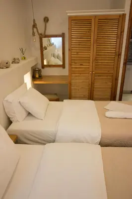 two beds in a room with a mirror at Ilias Apartments in Plataniás