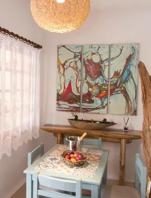 a dining room with a table with a bowl of fruit on it at Ilias Apartments in Plataniás
