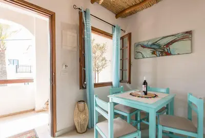 a blue table and chairs in a room with a window at Ilias Apartments in Plataniás