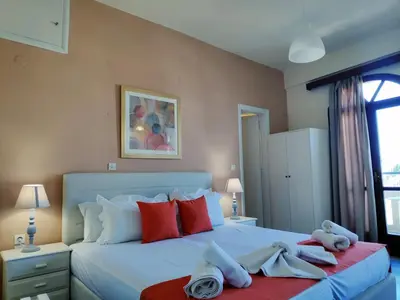 a bedroom with a large bed with towels on it at Creta Sun Studios in Kato Daratso