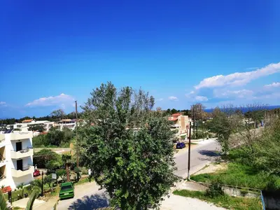 an empty street in a city with a tree at Creta Sun Studios in Kato Daratso