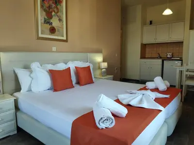 a bedroom with a large white bed with towels on it at Creta Sun Studios in Kato Daratso