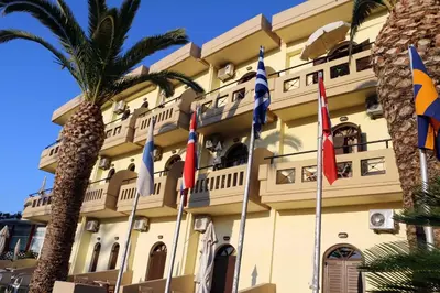 a building with flags in front of it at Creta Sun Studios in Kato Daratso