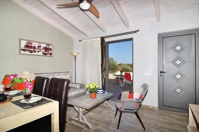 a living room with a couch and a table at Alexandra's Garden Houses in Stalos