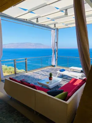 a living room with a couch and a view of the ocean at Athina Epavlis - Ethereal Charm of Blue Horizons in Ravdhoúkha