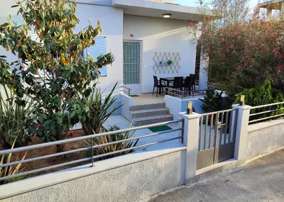 a white house with blue stairs and a fence at casa Marilia in Chania Town