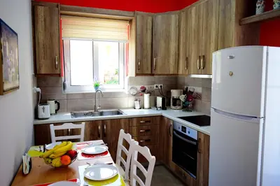 a kitchen with a table and a white refrigerator at casa Marilia in Chania Town