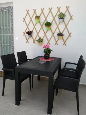 a black table and chairs with potted plants on the wall at casa Marilia in Chania Town