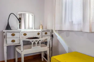 a white dressing table with a mirror and a chair at Casa Chrysa Chania 1st floor house with amazing view in Galatás