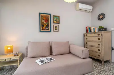 a living room with a couch and a dresser at Casa Chrysa Chania 1st floor house with amazing view in Galatás