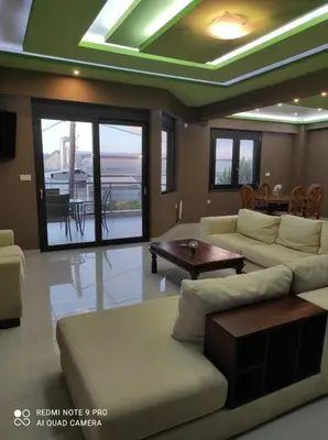 a living room with a couch and a table at Homieland Souda in Souda