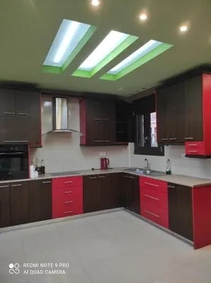 a large kitchen with red cabinets and a skylight at Homieland Souda in Souda