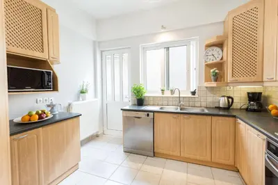 a kitchen with wooden cabinets and a sink at Marika's Guest House Chania in Chania Town