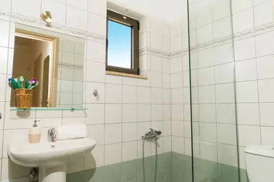 a bathroom with a sink and a glass shower at Villa Anthira in Ropanianá