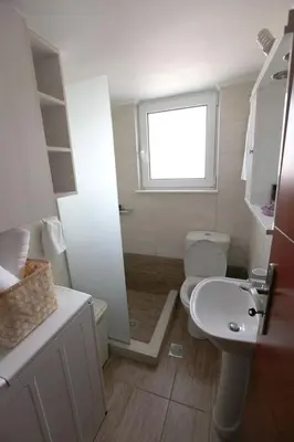 a bathroom with a toilet and a sink and a window at Rita's home in Chania Town