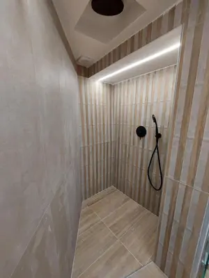 a bathroom with a shower with wooden walls and a ceiling at Evans House II One Bedroom Maisonette in Chania Town
