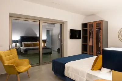 a bedroom with a king sized bed and a room with a television at NV Two in Chania Town