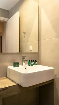a bathroom with a white sink and a mirror at NV Two in Chania Town