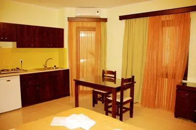 a kitchen with a table and chairs and a sink at Sandy Suites in Kalamaki Chanion