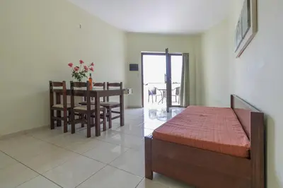 a bedroom with a bed and a table and a dining room at Sandy Suites in Kalamaki Chanion