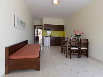 a kitchen and dining room with a couch and a table at Sandy Suites in Kalamaki Chanion