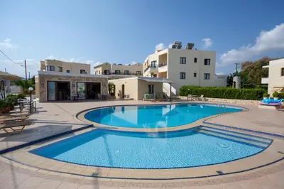 a large swimming pool in a courtyard with buildings at Sandy Suites in Kalamaki Chanion